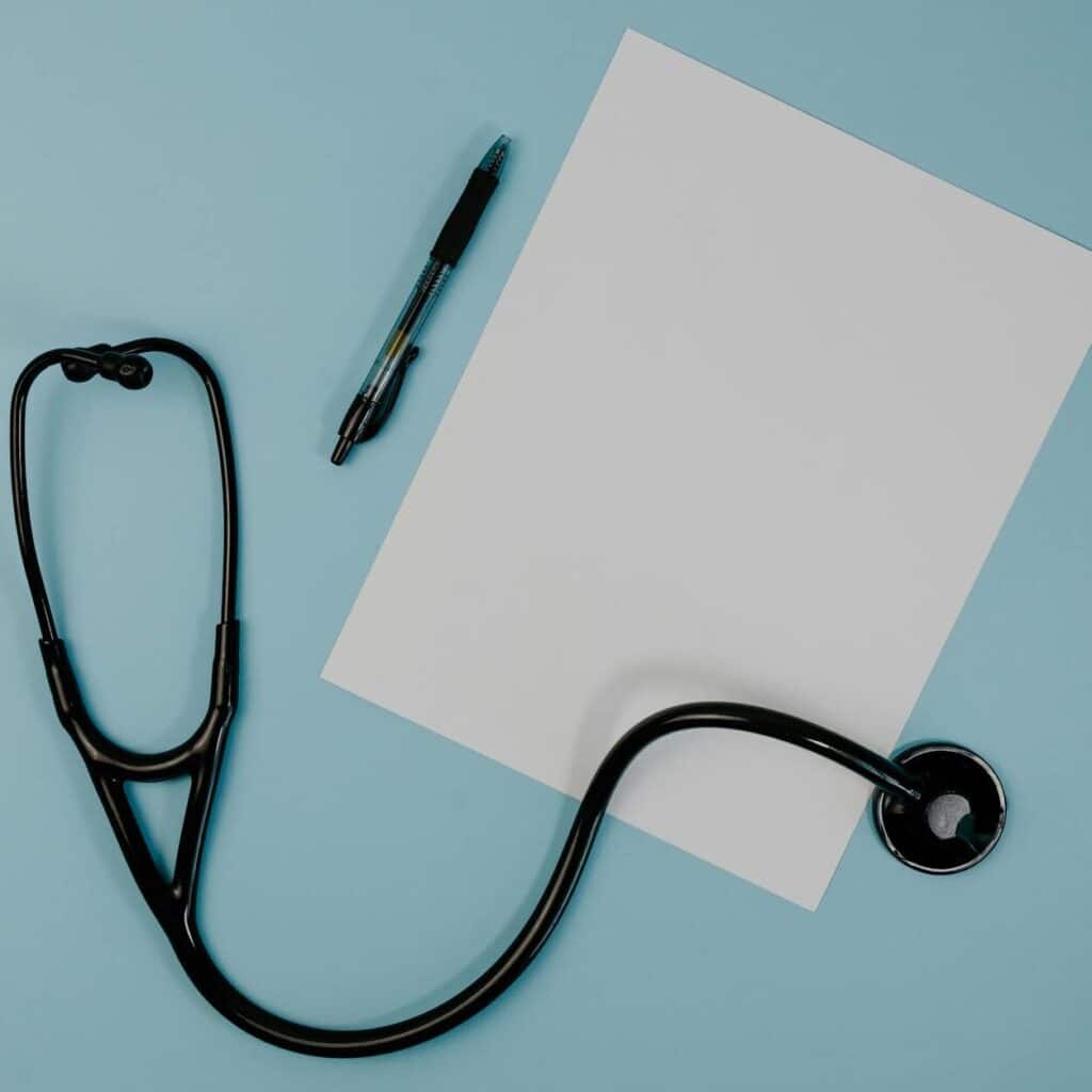 black stethoscope near the blank paper