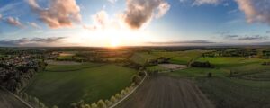 panoramic view of croplands and trees at sunset
